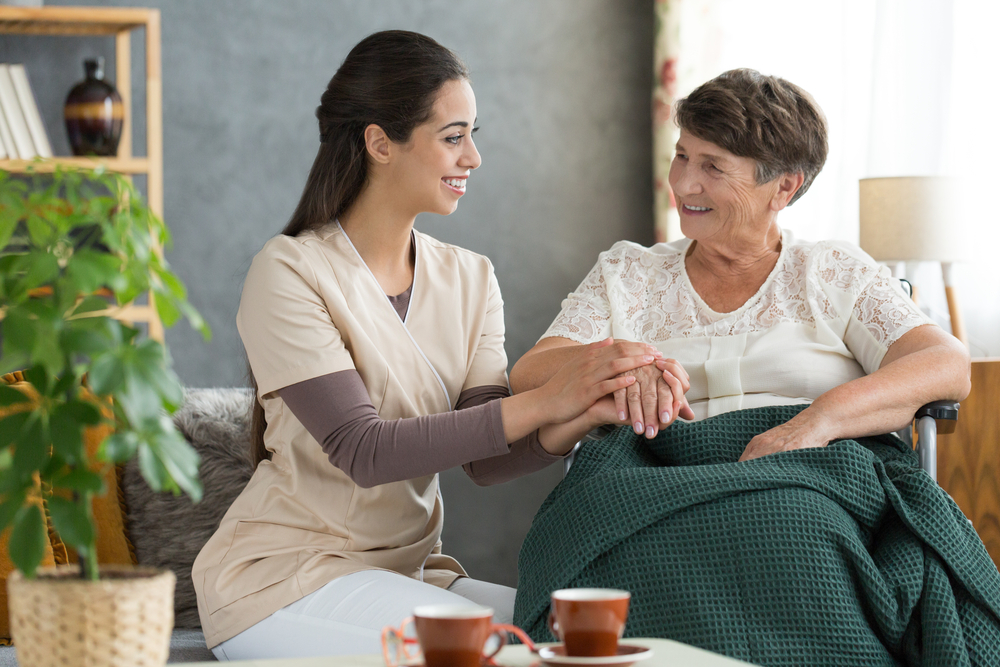 Retirement,home,volunteer,holding,elder,woman's,hand,in,gesture,of